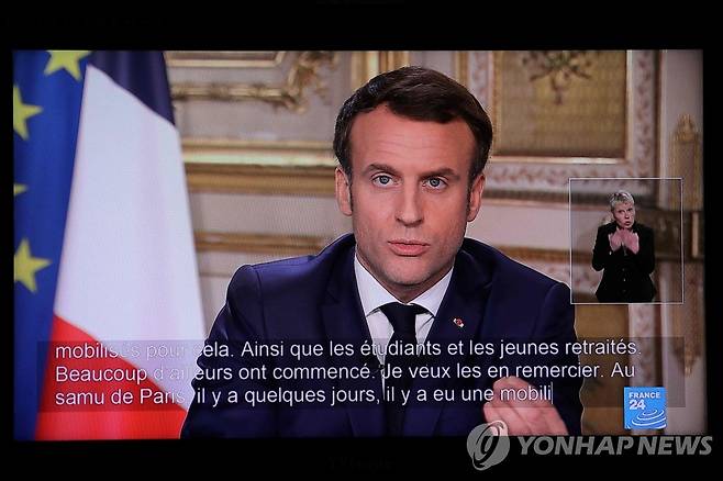 에마뉘엘 마크롱 프랑스 대통령이 지난 12일 엘리제궁에서 신종 코로나바이러스 감염증(코로나19) 사태와 관련한 대국민 특별담화를 하는 모습이 TV로 방영되고 있다. [AFP=연합뉴스 자료사진]