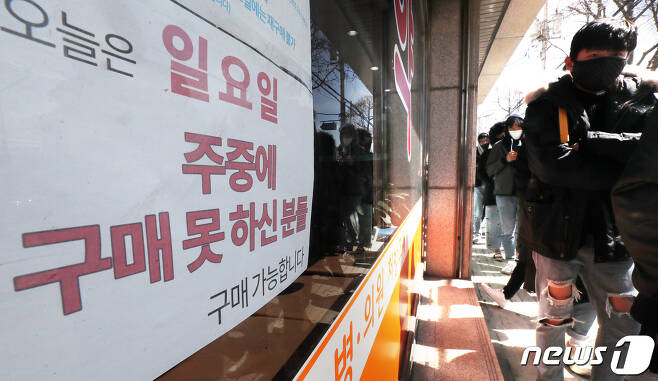 15일 오후 경기도 수원시내 한 약국 앞에서 시민들이 마스크를 구매하기 위해 길게 줄 서 있다. 2020.3.15/뉴스1 © News1 조태형 기자