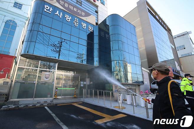 대구 서구 비산동 한사랑요양병원에서 환자와 직원 등 70여 명이 신종 코로나바이러스 감염증(코로나19)에 집단 감염된 사실이 알려진 가운데 18일 오후 서구보건소 관계자들이 요양병원 입구와 주변에 대한 방역을 실시하고 있다. 2020.3.18/뉴스1 © News1 공정식 기자