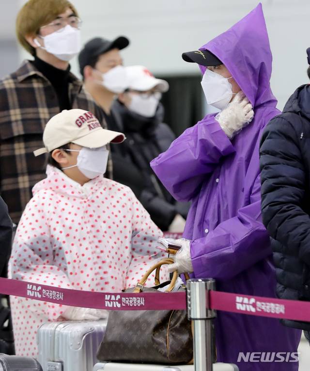 [제주=뉴시스]우장호 기자 = 신종 코로나바이러스 감염증(코로나19)이 확산 중인 지난 3일 제주국제공항 3층 출국장에서 한 중국인 모자(母子)가 우비를 입고 출국 순서를 기다리고 있다. 2020.03.03. woo1223@newsis.com