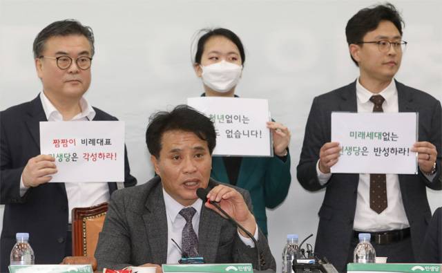 김명삼 민생당 공천관리위원장(앞줄)이 27일 오전 서울 영등포구 여의도 국회 민생당 회의실에서 발언하고 있다. 김 위원장 뒤로 비례대표 공천 신청자들이 공천 재심을 요구하며 시위를 벌이고 있다. 뉴시스