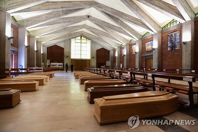 성당에 집단 안치된 이탈리아 코로나19 사망자 시신 (세리아테 AFP=연합뉴스) 이탈리아 북부 베르가모 인근의 소도시 세리아테의 한 가톨릭 교회 본당 내부에 26일(현지시간) 신종 코로나바이러스 감염증(코로나19) 사망자들의 시신이 안치된 관들이 2열로 놓여 있다. jsmoon@yna.co.kr