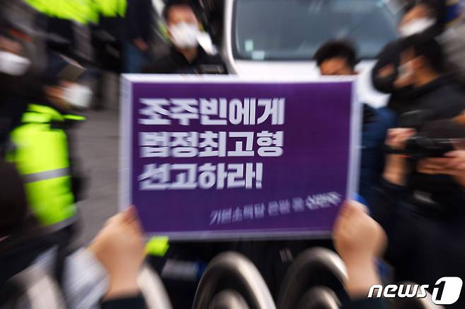 인터넷 메신저 텔레그램에서 미성년자를 포함한 여성들의 성 착취물을 제작 및 유포한 혐의를 받는 '박사방' 운영자 조주빈(25)이 25일 서울 종로구 종로경찰서 유치장에서 나와 검찰 유치장으로 향하자 시민들이 조주빈의 강력처벌을 촉구하며 피켓 시위를 하고 있다. . 2020.3.25/뉴스1 © News1 송원영 기자