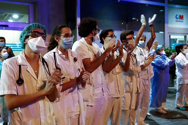 ⓒEPA스페인 마드리드 한 병원 앞에서 3월24일 시민들이 보내는 박수에 의료진이 화답하고 있다.