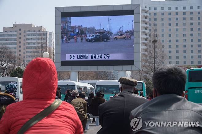 옥외 스크린 통해 코로나19 뉴스 지켜보는 평양 시민들 (평양 AFP=연합뉴스) 북한 평양 시민들이 지난 1일 중앙역 주변에서 대형 옥외스크린을 통해 신종 코로나바이러스 감염증(코로나19) 상황을 전하는 방송 뉴스를 지켜보고 있다. jsmoon@yna.co.kr