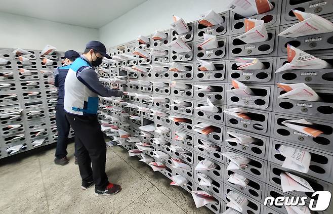 4·15 총선을 열흘 앞둔 5일 서울 마포구의 한 아파트에서 마포우체국 집배원들이 투표안내문·선거공보물을 우편함에 넣고 있다. 2020.4.5/뉴스1 © News1 허경 기자