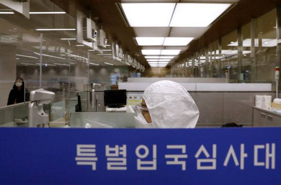 유증상자 전용 입국심사대 업무 준비 - 인천공항 출입국 외국인청 입국심사관이 8일 오후 인천국제공항 제2터미널 유증상자 전용 입국심사대에서 방진복을 입은 채 업무를 준비하고 있다.  2020.4.8 연합뉴스
