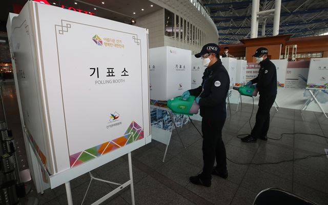 제21대 국회의원 선거 사전투표를 하루 앞둔 9일 서울 용산구 서울역에 마련된 남영동 사전투표소에서 방역업체 직원들이 소독 작업을 하고 있다. 배우한 기자