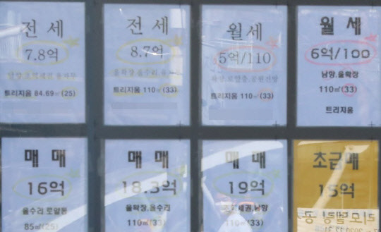 서울 시내의 한 부동산 유리창으로 주변 아파트 시세표와 길을 지나는 주민의 모습이 겹쳐 보인다.<연합뉴스>