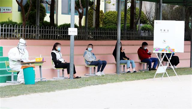 자가격리자 투표 기다리는 중 - (인천=뉴스1) 정진욱 기자 = 15일 오후 인천시 계양구 신대초등학교에서 자가격리자들이 투표를 하기 위해 기다리고 있다. 2020.4.15/뉴스1
