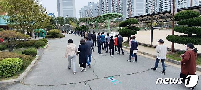 21대 국회의원선거 사전투표 이틀째인 지난 11일 오후 광주 서구 전남중학교에 마련된 치평동 사전투표소 앞에 투표하려는 시민들이 길게 줄을 서고 있다.2020.4.11/뉴스1 © News1 박준배 기자