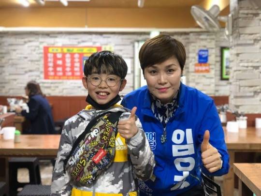 임오경 더불어민주당 국회의원 당선자가 선거운동기간 중 광명시장에서 어린애와 포즈를 취하고 있다. [임오경 당선자 페이스북 캡처]