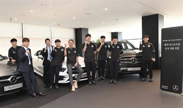 이지훈(왼쪽에서 세 번째) 젠지 단장과 최우범(왼쪽에서 두 번째) 젠지 감독, 선수단이 울프 아우스프룽(왼쪽에서 다섯 번째) 한성자동차 대표 메르세데스-벤츠 차량 지원 등이 담긴 파트너십 계약을 체결하고 화이팅 포즈를 취하고 있다. 젠지e스포츠 제공