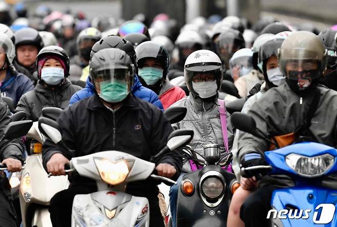 (타이베이 AFP=뉴스1) 우동명 기자 = 18일(현지시간) 타이베이에서 코로나19 감염을 막기위해 마스크를 쓴 시민들이 오토바이를 타고 출근을 하고 있다.   ⓒ AFP=뉴스1