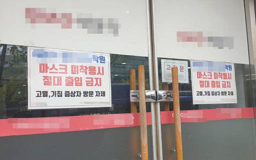 20일 서울 동작구의 한 학원 입구에 '마스크 미 착용시 절대 출입 금지'라는 안내문이 붙어 있다. 연합뉴스