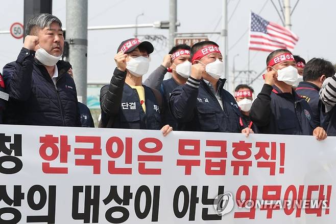 '무급휴직 철회하라' (평택=연합뉴스) 권준우 기자 = 1일 오후 경기 평택시 캠프 험프리스 미군기지 정문 앞에서 전국주한미군한국인노조 조합원들이 무급휴직 상태 정상화를 촉구하는 구호를 외치고 있다.       정부는 한미 방위비분담금협정(SMA) 결렬로 주한미군 전체 한국인 근로자 8천600여 명의 절반가량인 4천여 명이 이날부터 무급휴직에 들어간 것으로 추정하고 있다. 2020.4.1 stop@yna.co.kr