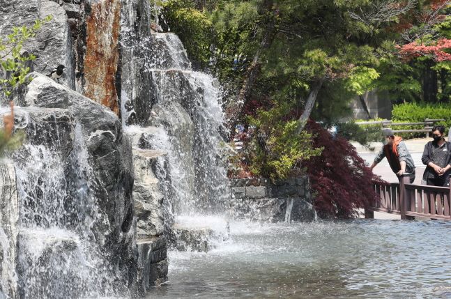 초여름 날씨처럼 따뜻했던 29일 오후 시민들이 인천시 남동구 중앙공원에서 폭포처럼 흘러내리는 시원한 물줄기를 보고 있다.ⓒ뉴시스
