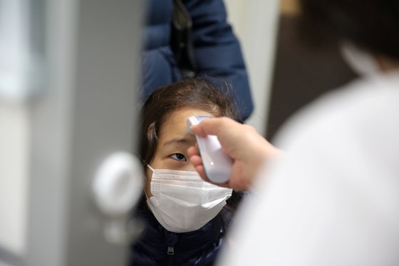 어린이날인 지난 5일 마스크를 쓴 어린이가 일본 도쿄의 한 어린이 돌봄센터에 입장하기 전 체온을 측정하고 있다. [로이터=연합뉴스]