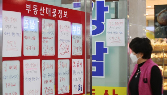 한 시민이 부동산 공인중개업소 게시판에 걸린 급매물 시세를 들여다보고 있다.<연합뉴스>
