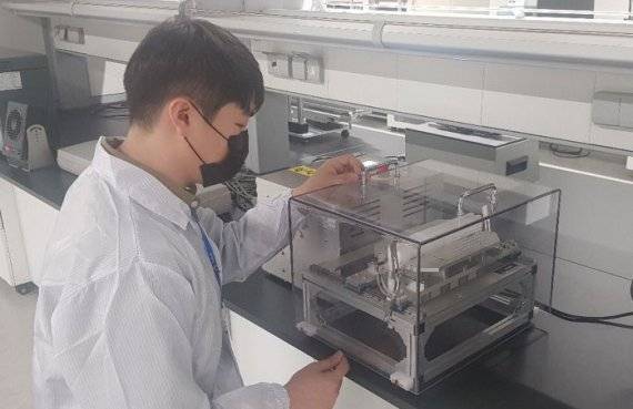 코오롱인더스트리 연구원이 서울 마곡 코오롱인더스트리 연구소에서 폴더블폰의 핵심 소재인 투명폴리이미드(CPI) 폴딩테스트를 지켜보고 있다. 코오롱 제공