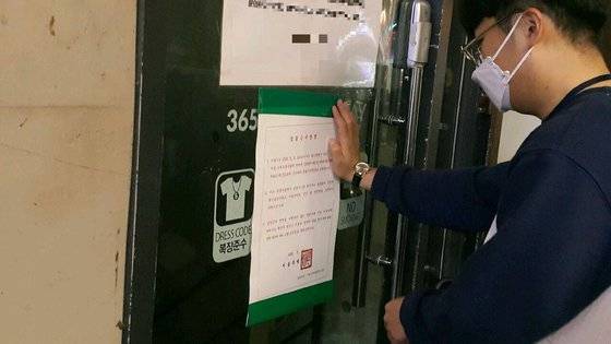 9일 서울 마포구청 위생관리과 직원이 홍대 인근의 한 클럽에 '집합금지명령서'를 부착하고 있다. [마포구청 제공]