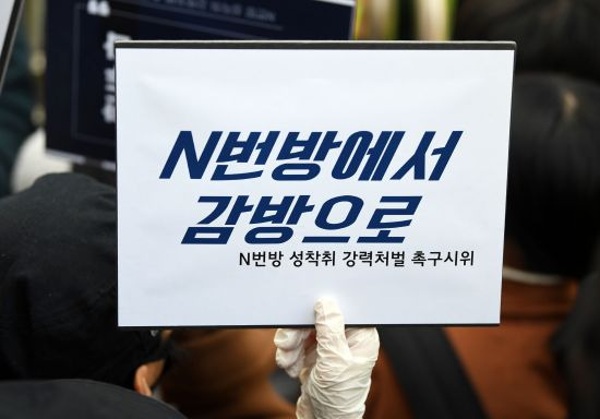 지난 3월 25일 인터넷 메신저 텔레그램에서 미성년자를 포함한 여성들의 성 착취물을 제작 및 유포한 혐의를 받는 '박사방' 운영자 조주빈이 탄 차량이 서울 종로경찰서를 나와 검찰 유치장으로 향하자 시민들이 조주빈의 강력처벌을 촉구하며 피켓 시위를 하고 있다. 연합뉴스