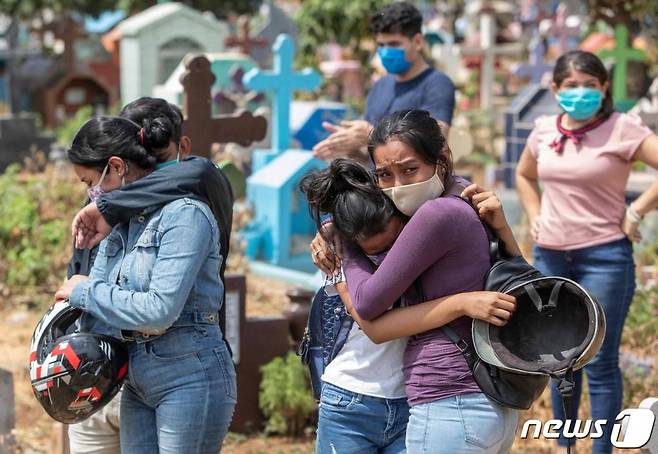 (AFP=뉴스1) 9일(현지시간)니카라과의 수도 마나과에 있는 밀라그로 드 디오스 묘지에서 신종코로나감염증(코로나19)로 사망한 로베르토라 정비사의 친척과 친구들이 슬픔에 잠겨 있다  ⓒ AFP=뉴스1