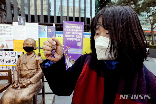 [서울=뉴시스]김병문 기자 = 윤미향 전 정의기억연대 이사장이 8일 오후 서울 종로구 옛 일본대사관 앞에서 온라인으로 열린 일본군 성노예제 문제해결을 위한 제1434차 정기수요시위에 참석해 보라색 리본 배지를 들어보이고 있다. 2020.04.08.  dadazon@newsis.com