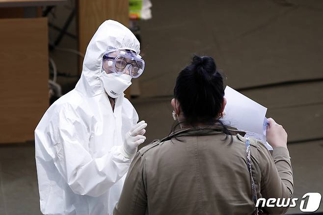 서울 이태원발 신종 코로나바이러스 감염증(코로나19) 확진자가 급속히 늘고 있는 11일 서울 용산구 보건소에 마련된 선별진료소에서 의료진이 시민에게 안내사항을 전달하고 있다.2020.5.11/뉴스1 © News1 안은나 기자