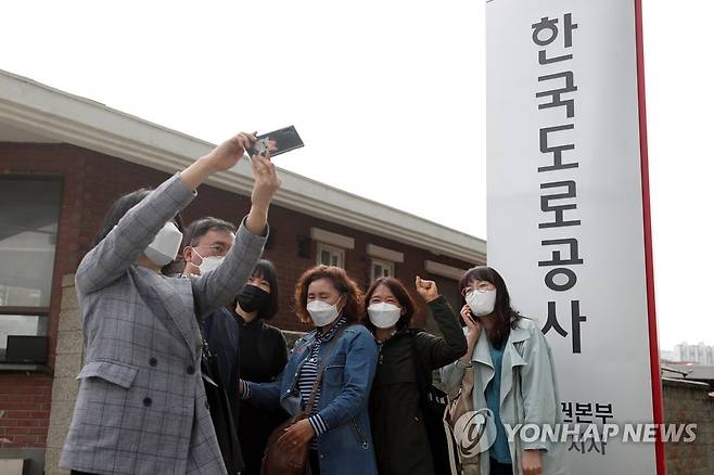 셀카로 만끽하는 복직의 기쁨 (용인=연합뉴스) 권준우 기자 = 14일 오전 도로공사 비정규직의 정규직 전환 과정에서 자회사 전환 방식에 반대해 해고됐던 톨게이트 요금 수납원들이 319일만에 복직, 경기도 용인시 기흥구 한국도로공사 수원지사로 출근하던 중 현판 앞에서 기념촬영을 하고 있다. 2020.5.14 stop@yna.co.kr