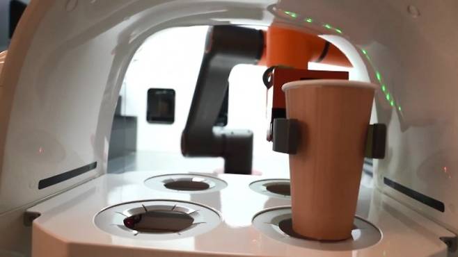 바리스타 로봇이 서빙로봇 ′토랑′에 음료를 전달하고 있다. 비전세미콘 제공