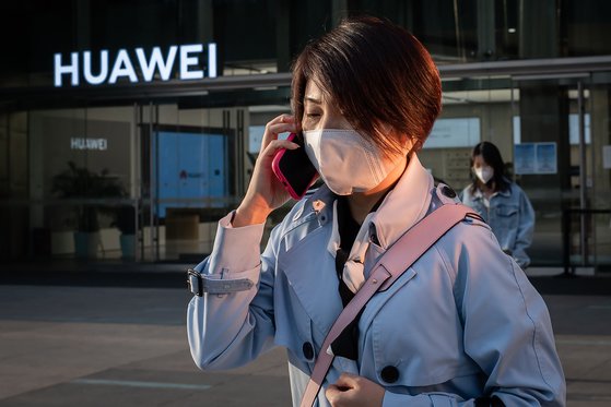 지난달 1일 중국 베이징에서 한 여성이 마스크를 쓴 채 화웨이 매장 앞을 지나가고 있다.[AFP=연합뉴스]