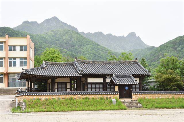 문경 관아의 객사인 관산지관 뒤로 주흘산 능선이 우람하다. 문경서중학교 교정에 있다.