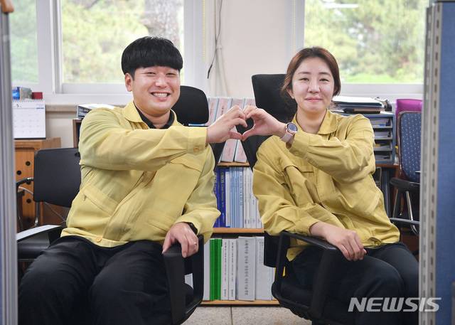 [서울=뉴시스] 해군 군수사령부 함정기술연구소 기관연구과에서 군무원으로 함께 근무하는 이재영(32), 정현주(31)부부가 손으로 사랑의 하트를 만들어 보이고 있다. 두 사람은 사무실에서 등을 맞대고 서로를 의지하면서 근무하고 있다. 2020.05.20. (사진=해군 제공)