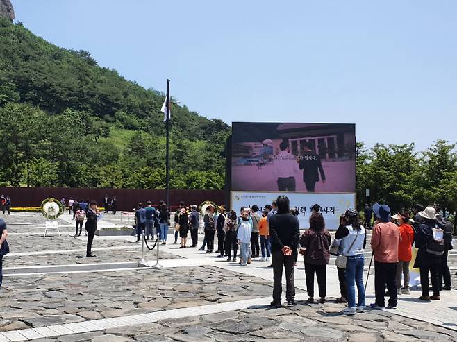 23일 경남 김해 봉하마을에서 열린 노무현 전 대통령 서거 11주기 추모식을 맞아 시민들이 묘역에 헌화하기 위해 간격을 두고 줄서 기다리고 있다/김해=최승균 기자/
