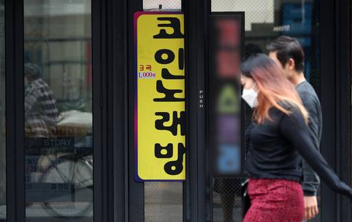 지난 24일 경기도 수원시 인계동의 한 코인노래방 입구 앞으로 시민들이 지나고 있다. 수원=뉴스1