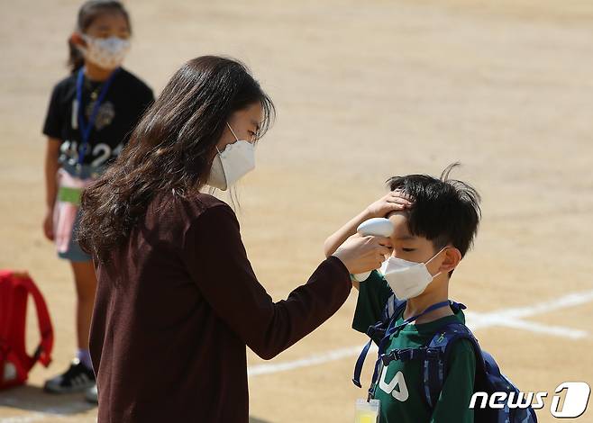 27일 대구 한 초등학교 운동장에서 신종 코로나바이러스 감염증(코로나19) 확산 여파로 온라인 입학 후 87일만에 처음으로 등교한 1학년 신입생들이 발열 검사를 받고 있다. /뉴스1 © News1 공정식 기자