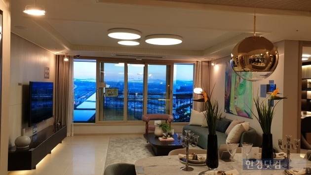 '검암역 로열파크씨티 푸르지오' 전용 84㎡A형 거실. 우물천장과 개성있는 조명이 특징이다. 아라뱃길 방면으로 배치된 가상의 조망을 넣었다. (사진 김하나 기자)