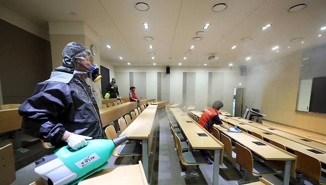 지난 11일 오후 인천 미추홀구 인하대에서 방역업체 관계자들이 강의실을 소독하고 있다. [연합]