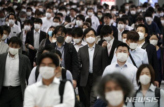 [도쿄=AP/뉴시스]지난달 26일 일본 도쿄의 한 지하철 역이 마스크를 쓴 채 출근하는 사람들로 붐비고 있다.