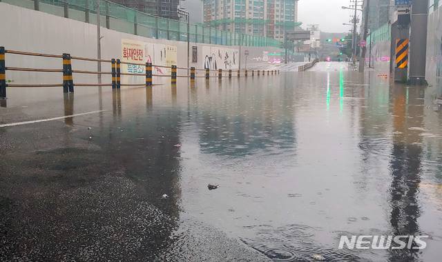 [부산=뉴시스] 호우경보가 발효된 13일 부산 동래구의 한 아파트 신축현장 앞 도로가 침수돼  양방향 4개 차로 300m 구간의 차량 통행을 전면 통제했다. (사진=부산경찰청 제공)photo@newsis.com