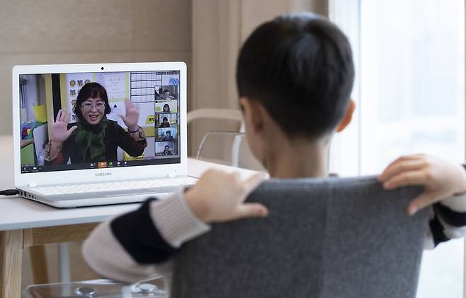 4월20일 오전 서울 용산구의 한 가정에서 용산초등학교 1학년에 입학한 신입생 어린이가 노트북 화면을 통해 온라인 입학식을 하며 화면 속의 인사하는 선생님을 바라보고 있다. 코로나19 여파로 인한 사상 초유의 ‘온라인 개학'에 이날 초등학교 1∼3학년이 마지막으로 합류했다. 이달 9일 중3·고3 85만8천여명에 이어 16일 중·고 1∼2학년과 초등 4∼6학년 312만6천여명이 원격수업을 시작했고, 이날 초등 1∼3학년 137만여명이 개학 연기 49일 만에 선생님을 원격으로 만났다. 연합뉴스