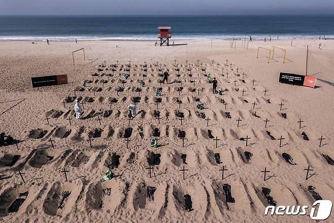 11일(현지시간) 브라질 리우데자네이루의 코파카바나 해변에서 NGO 활동가들이 코로나19 사망자를 상징화한 가짜 무덤을 파고 있다. © AFP=뉴스1 © News1 우동명 기자