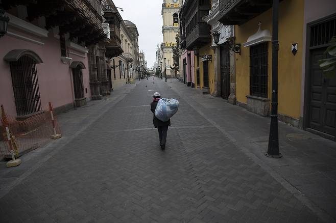 페루 리마에서 14일(현지시간) 한 남성이 봉쇄 조치로 텅 비어 있는 거리를 걷고 있다. 리마｜AP연합뉴스