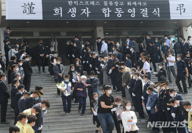 [이천=뉴시스] 김종택기자 = 20일 오전 경기 이천 서희 청소년문화센터에서 열린 '이천 한익스프레스 물류창고 화재 사고 희생자 합동 영결식'에서 유가족들이 위패와 영정사진을 들고 영결식장을 나서고 있다. 2020.06.20.semail3778@naver.com