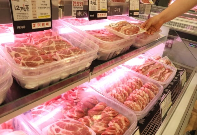돼지고기 목살 가격이 한 달 새 20%나 오른 23일 오전 서울의 한 대형마트에서 한 고객이 돼지고기를 보고 있다. 연합뉴스