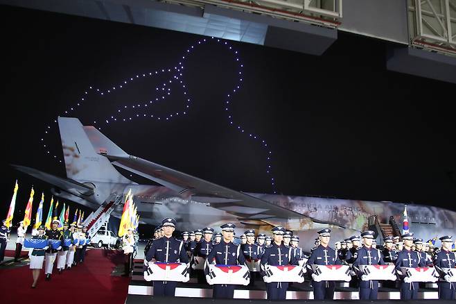 북한에서 발굴된 6·25 국군 전사자 유해 147구를 미국 하와이에서 서울공항으로 모셔온 공군 공중급유기 시그너스(KC-330) 기체에 미디어파사드 영상이 투영되고 있다. 기체 뒤로 거수경례하는 군인을 형상화한 드론 불빛들이 보인다. 성남/청와대사진기자단
