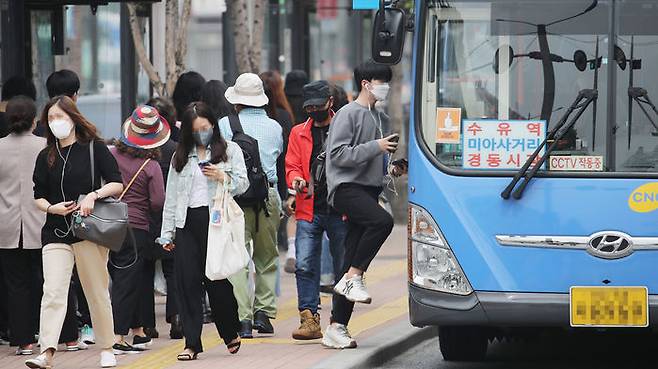 마스크를 쓴 서울 시내 한 버스정류장의 시민들