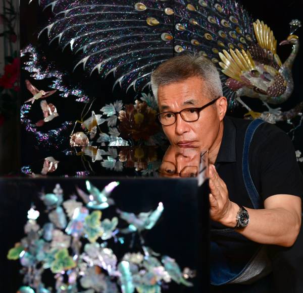 유철현씨가 작은 자개장 표면의 마감 상태를 확인하고 있다.