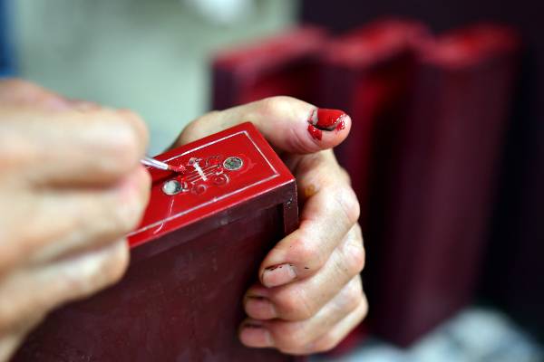 자개장에 쓰이는 작은 서랍에 칠 작업이 한창이다. 깔끔한 채색을 위해 엄지손톱을 팔레트처럼 사용하고 있다.